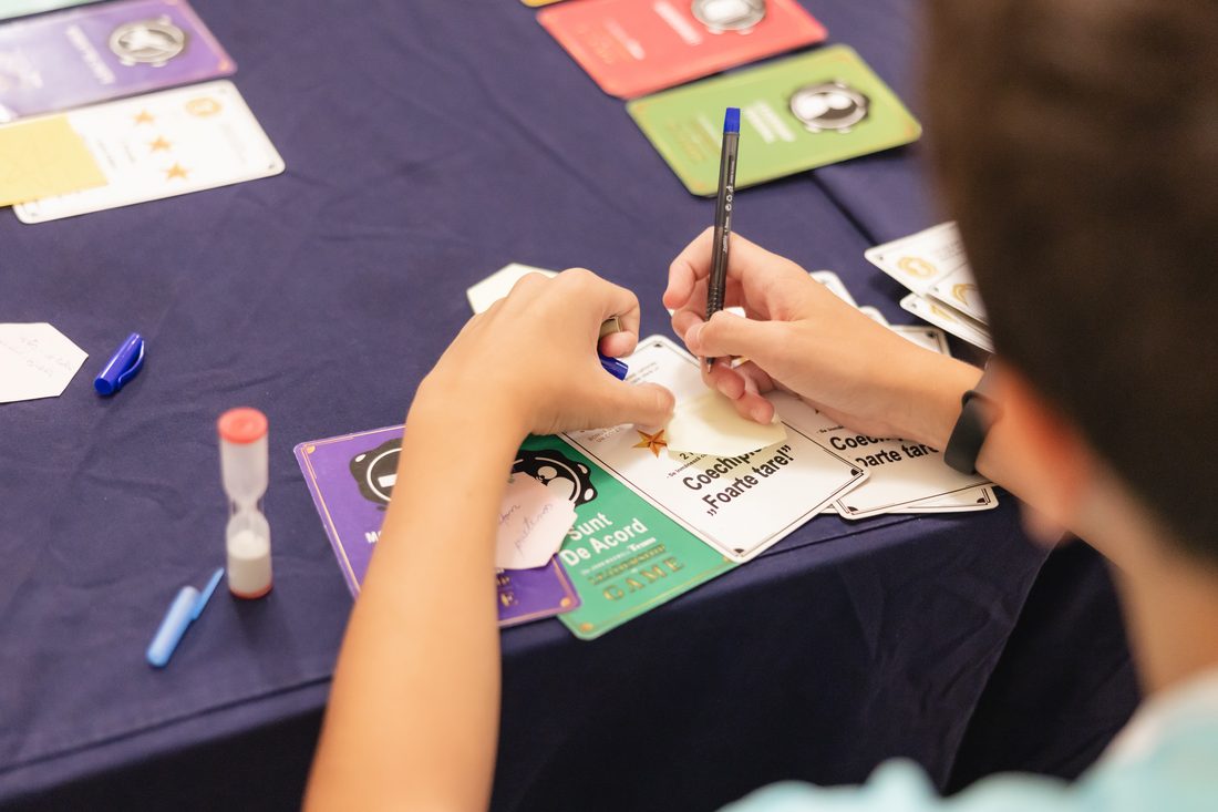 Participant scriind pe un cartonaș în timpul unui atelier la IMC 2026.
